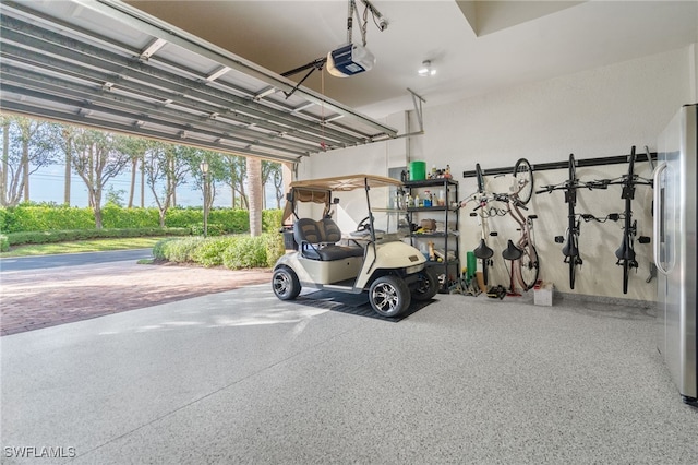 garage with a garage door opener and stainless steel refrigerator