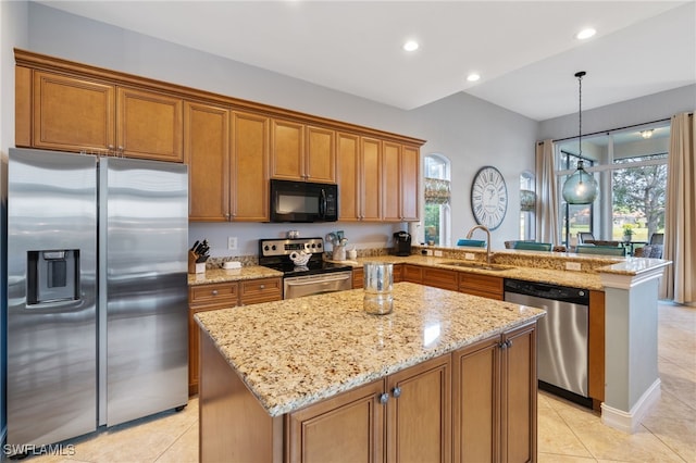 kitchen featuring pendant lighting, sink, stainless steel appliances, a kitchen island, and kitchen peninsula