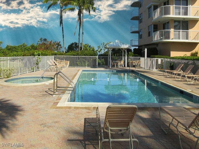 view of pool with a patio area and a hot tub