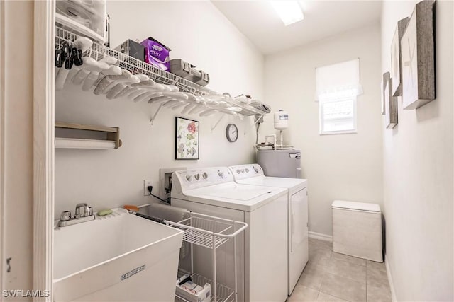 laundry area featuring light tile patterned flooring, separate washer and dryer, sink, and water heater