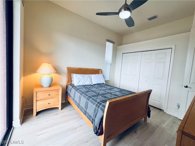 bedroom featuring ceiling fan, light hardwood / wood-style flooring, and a closet