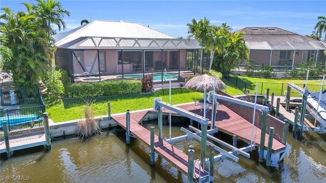 dock area with a lanai, a yard, and a water view