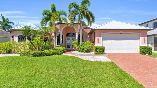 view of front of property featuring a front lawn, a garage, and french doors