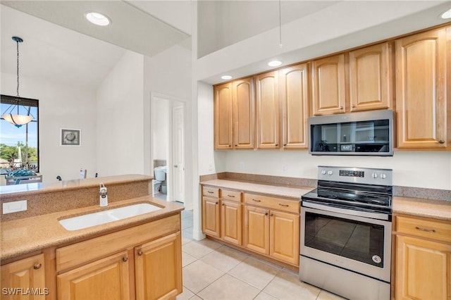 kitchen with appliances with stainless steel finishes, sink, light brown cabinets, light tile patterned floors, and pendant lighting