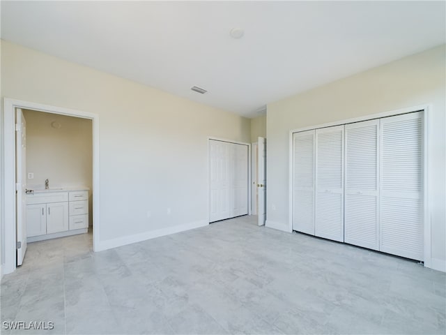 unfurnished bedroom featuring connected bathroom and sink