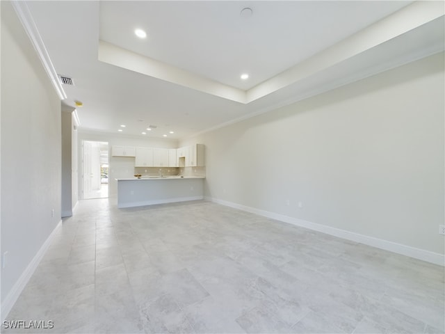 unfurnished living room featuring a tray ceiling and crown molding