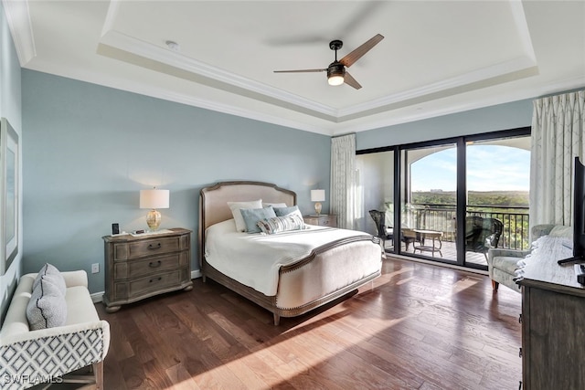 bedroom featuring ceiling fan, dark hardwood / wood-style flooring, access to exterior, and a tray ceiling