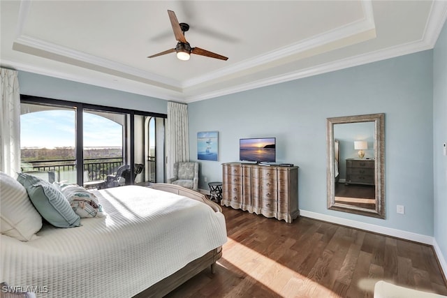 bedroom with a tray ceiling, ceiling fan, and dark wood-type flooring