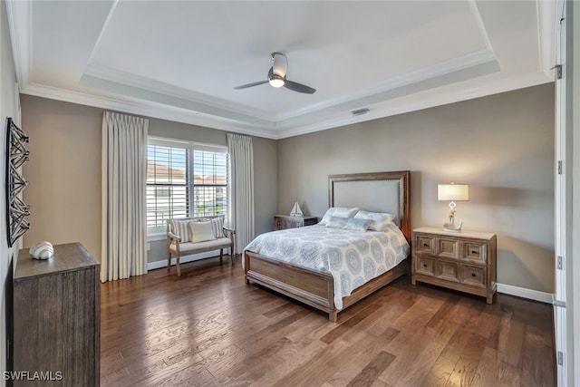 bedroom with ceiling fan, wood-type flooring, crown molding, and a tray ceiling