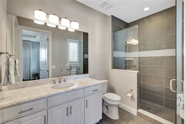 bathroom with tile patterned flooring, vanity, a shower with shower door, and toilet