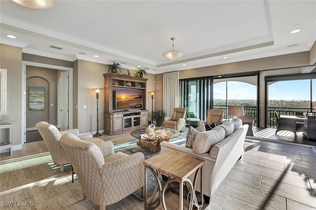 living room with a raised ceiling and ornamental molding