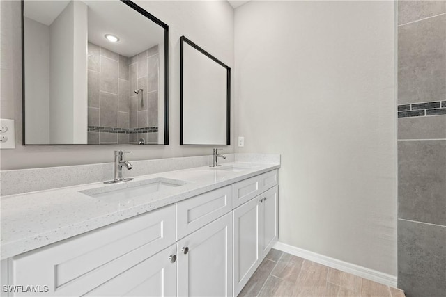 bathroom with vanity and a tile shower