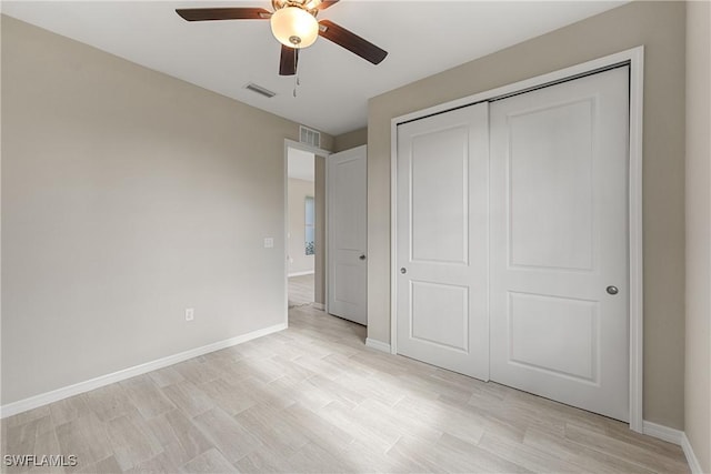 unfurnished bedroom featuring ceiling fan, a closet, and light wood-type flooring