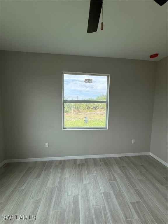 spare room featuring ceiling fan and light hardwood / wood-style flooring