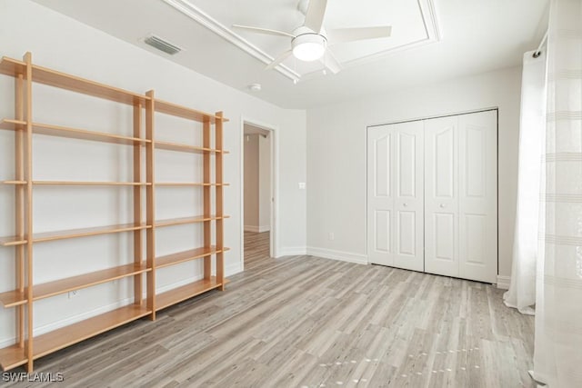 unfurnished bedroom featuring ceiling fan, light wood-type flooring, and a closet