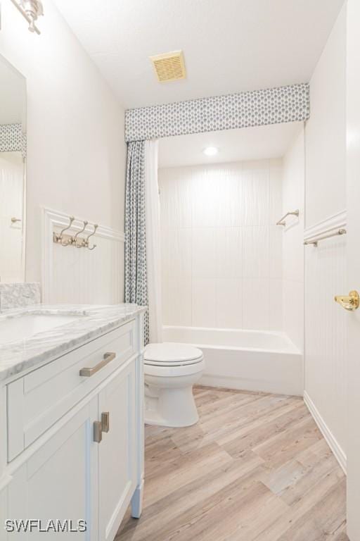 full bathroom with shower / bath combination with curtain, toilet, wood-type flooring, and vanity