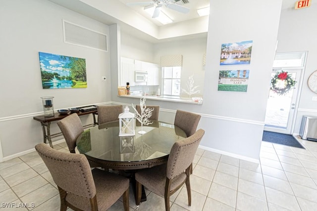 dining space with ceiling fan and light tile patterned flooring