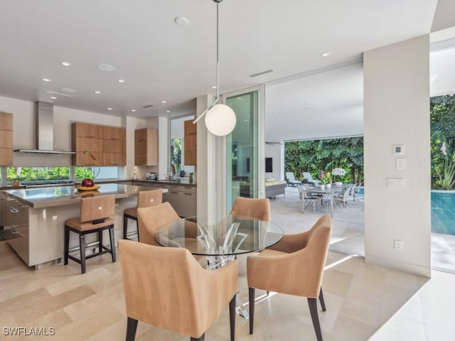 dining area featuring a wall of windows, recessed lighting, and a healthy amount of sunlight