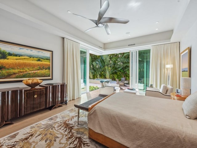 bedroom featuring ceiling fan, wood finished floors, and access to exterior