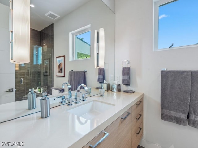 full bathroom featuring a stall shower, plenty of natural light, visible vents, and vanity