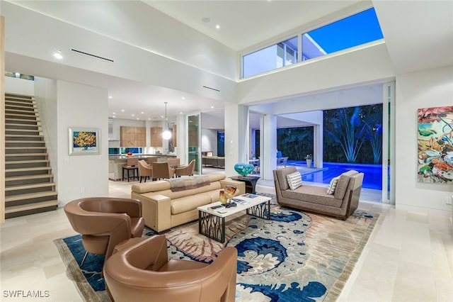 living room with stairway, a towering ceiling, and recessed lighting