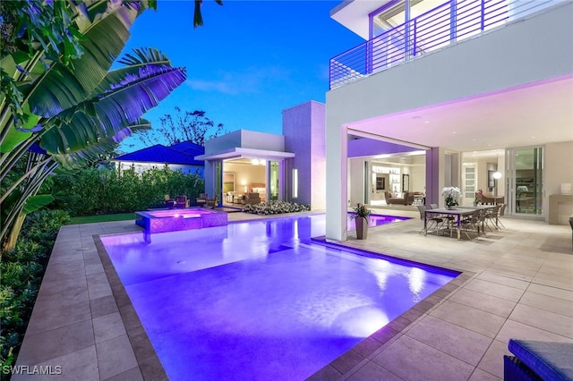 view of swimming pool featuring a patio area, a pool with connected hot tub, and outdoor dining area