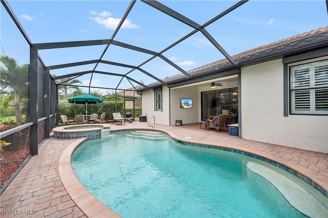 view of pool featuring a lanai, a patio area, an in ground hot tub, and ceiling fan