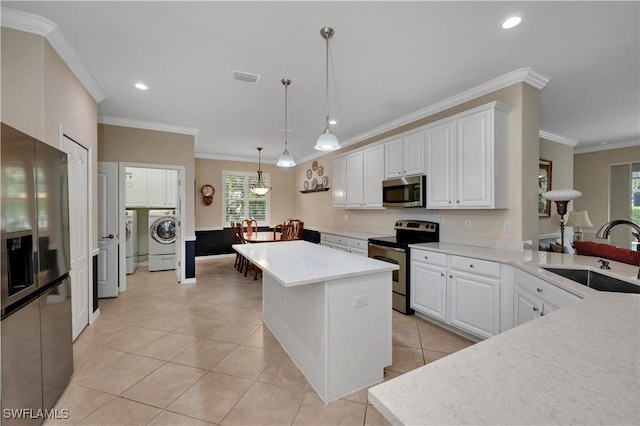 kitchen featuring appliances with stainless steel finishes, sink, light tile patterned floors, decorative light fixtures, and white cabinets