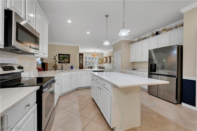 kitchen featuring kitchen peninsula, appliances with stainless steel finishes, sink, decorative light fixtures, and a center island