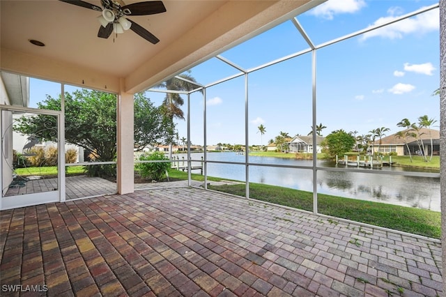 unfurnished sunroom featuring ceiling fan and a water view