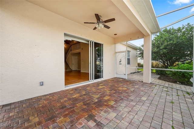 view of patio featuring glass enclosure and ceiling fan