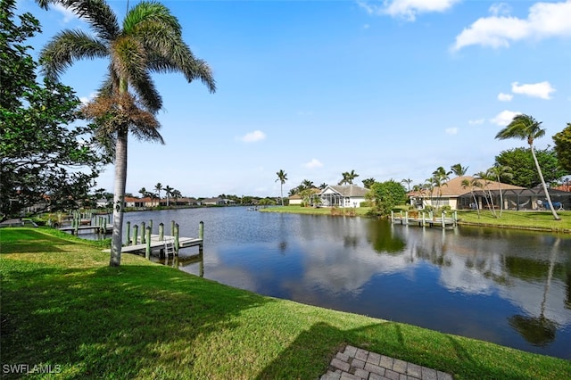 view of dock with a yard and a water view