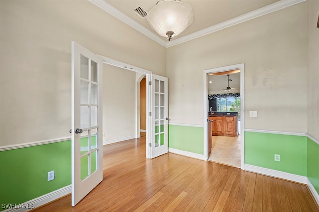 spare room with hardwood / wood-style flooring, french doors, and ornamental molding