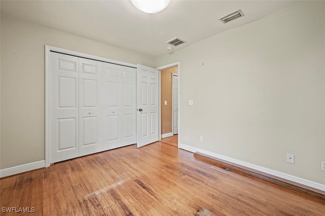 unfurnished bedroom with a closet and light hardwood / wood-style flooring