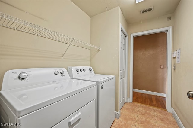 washroom with light tile patterned flooring and washer and dryer