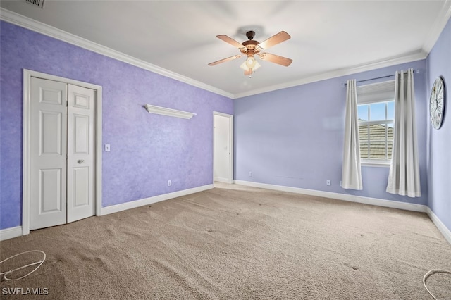 carpeted empty room with crown molding and ceiling fan