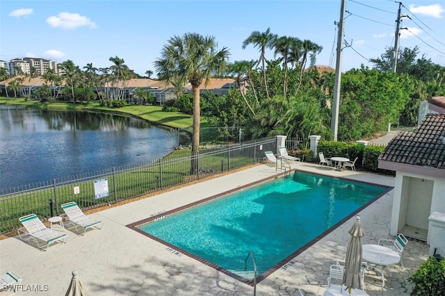 view of swimming pool with a water view and a patio