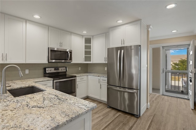 kitchen featuring light stone countertops, sink, white cabinets, and stainless steel appliances