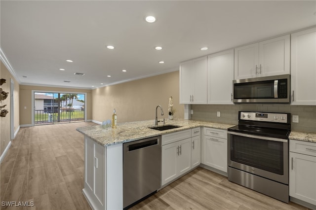 kitchen featuring stainless steel appliances, white cabinetry, and sink