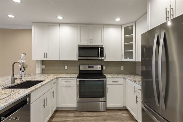 kitchen featuring appliances with stainless steel finishes, white cabinetry, and sink