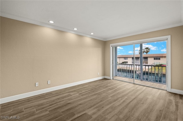 empty room with wood-type flooring and crown molding