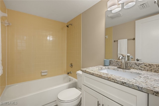 full bathroom with tiled shower / bath, vanity, and toilet