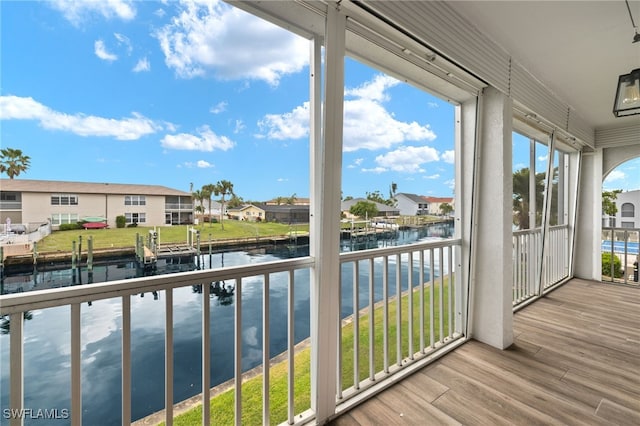 sunroom featuring a water view