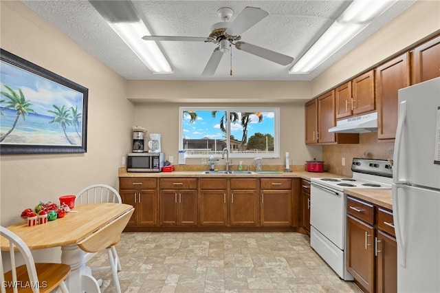 kitchen featuring a textured ceiling, white appliances, ceiling fan, and sink