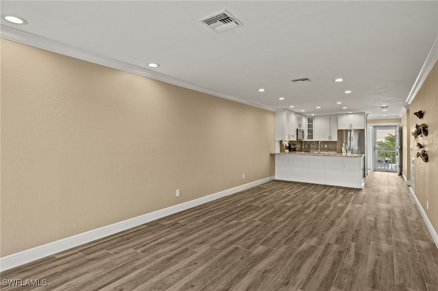 unfurnished living room featuring sink, dark wood-type flooring, and ornamental molding