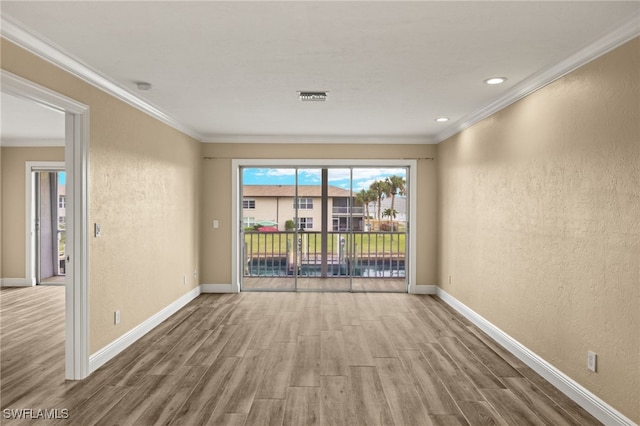 spare room with hardwood / wood-style flooring and ornamental molding