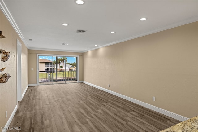 empty room with hardwood / wood-style flooring and ornamental molding