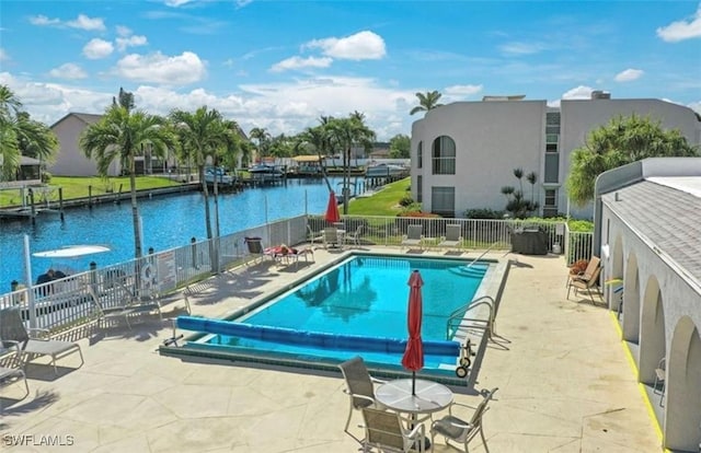 view of pool featuring a patio and a water view