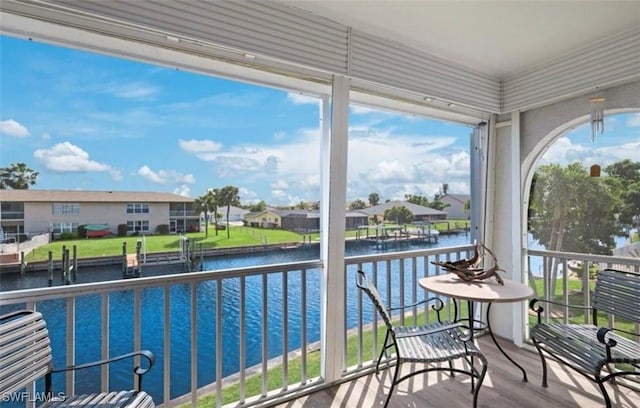 sunroom / solarium featuring a water view