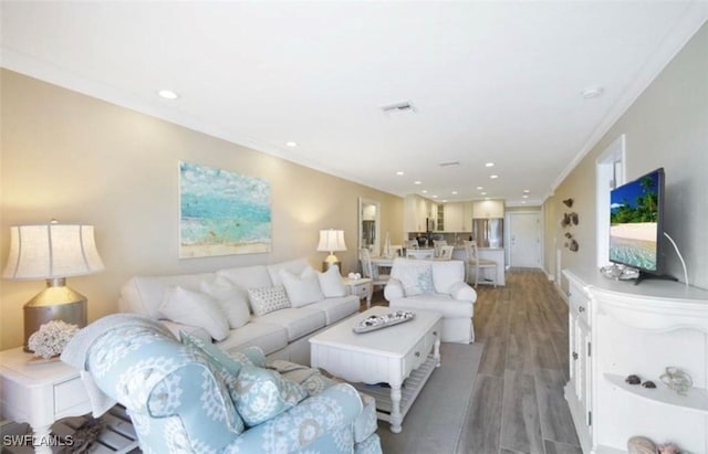 living room with hardwood / wood-style flooring and crown molding